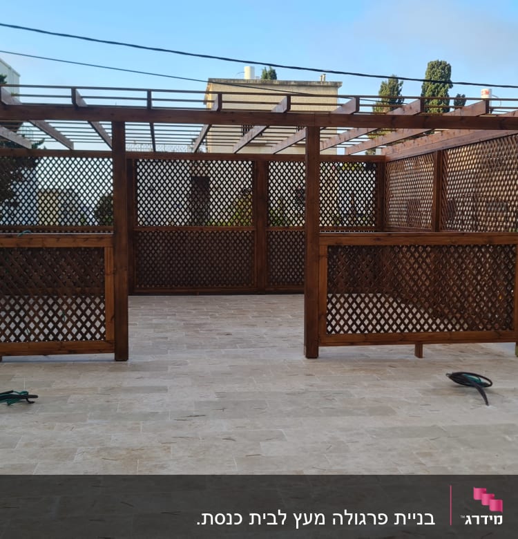 פרגולה מעץ עם רשתות דקורטיביות בחצר